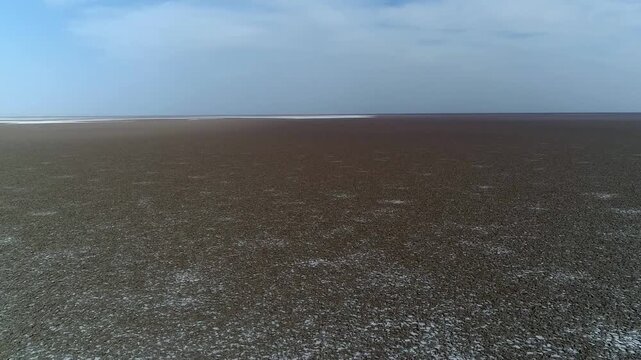 High quality drone footage showing expansive salt marsh plain with distant features.