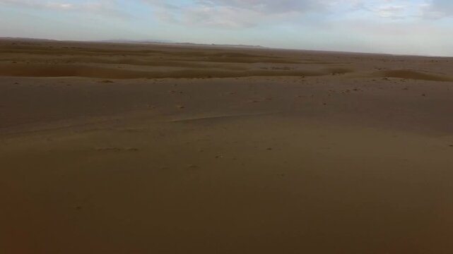 Stunning panoramic drone footage of wide desert plain with soft textures.