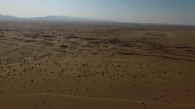 Aerial footage showing desert plain extending to distant horizon.