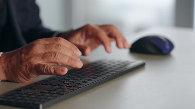 A male business professional operating a PC keyboard. Typing, data entry, programming, systems, engineer.
