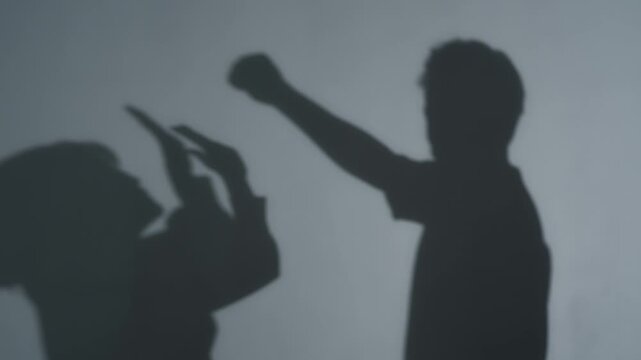女性に拳を振り上げる男性のシルエット。DV、パワハラ、脅迫、暴行、喧嘩、夫婦、児童虐待、児童相談所
