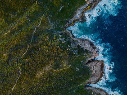 Aerial view of the blowholes at Torndirrup National Park with crashing waves against rocky cliffs and green coastal vegetation Torndirrup, Western Australia, Australia.