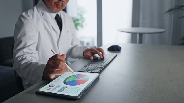 A man in a white coat working with a computer and a tablet PC. Science, research, DX, IT, medical, doctor, development, data.