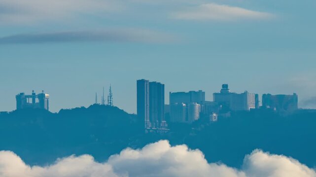 Telephoto view of Genting Highlands mountain time lapse at day, city above clouds in the sky
