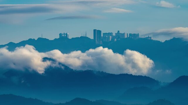 Birds eye view of Genting Highlands cityscape on top of Malaysia Mountain, cloud time lapse in background