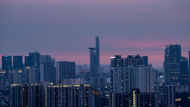 Kuala Lumpur, Malaysia time lapse during sunset, Menara Telekom in the background, apartment building lights up.