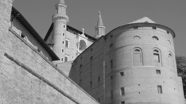 Historical duke palace in Urbino, Italy on sunny day, architectural marvel captured in smooth panning motion.