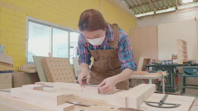 A dedicated artisan is engaged in woodworking, meticulously crafting furniture pieces in a bright workshop filled with tools and materials. The focus is on precision and artistry in furniture design.