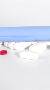 Beautiful vertical layout showing a blue semaglutide injection pen and diabetes medication pills panning on rotating wooden framework