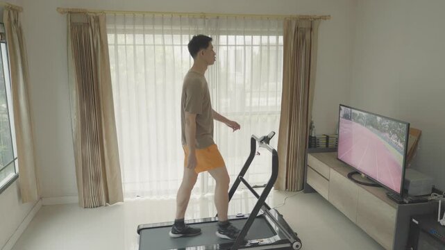 A person engages in a home workout on a treadmill while watching a screen. The bright interior and relaxing environment encourage fitness and well-being.