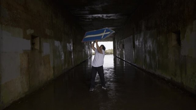Young Guy Doing Spin Tricks With Sign Inside Concrete Tunnel - Steady Cam Forward