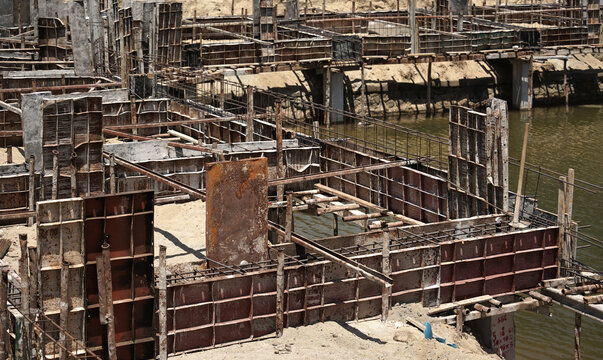 Building process city levee. Exposed foundation rebar grid at site, standing formwork and concrete footings