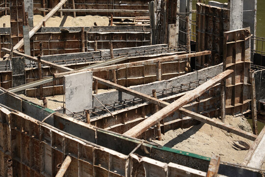 Building process city levee. Exposed foundation rebar grid at site, standing formwork and concrete footings