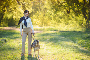 Fototapeta premium Woman and dog enjoying a walk in park