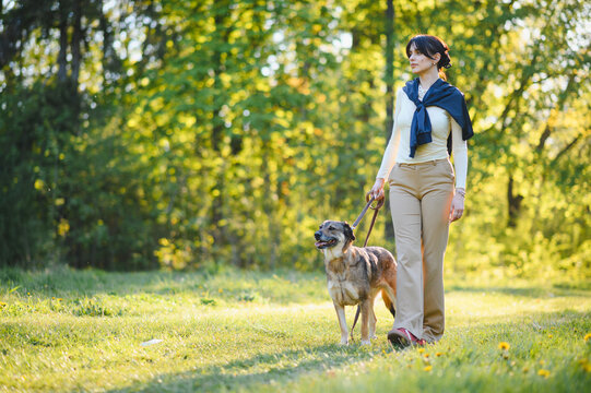 Woman walking dog in park enjoying leisure time