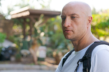 Bald Caucasian Man Profile Portrait with Backpack in Garden © Екатерина Переславце