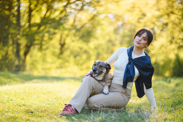 Fototapeta premium Happy woman relaxing with dog in park