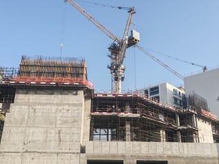 High rise under construction building with their incomplete structure. tall building with their tower crane erected beside it and having scaffolding around the building. concrete structure tower  © Usama