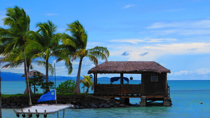 Overwater Bungalow with Palm Trees and Catamaran © VJH Photography