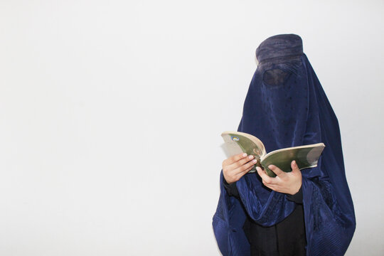 Afghan Muslim women with burka traditional costume, reading Book
