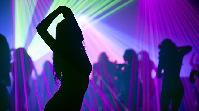 People enjoying music and dancing in a vibrant nightclub under colorful laser beams
