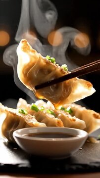 Steaming hot gyoza dumplings dipped in soy sauce with chopsticks against a dark background