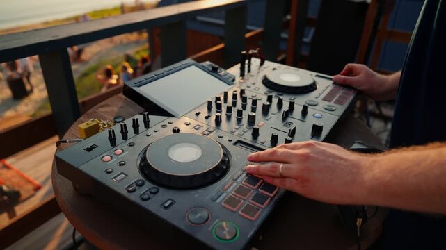 focused dj hands mixing music in a professional booth overhead view with plastic and wood materials and gray and black colors, commercial natural light and clean background.