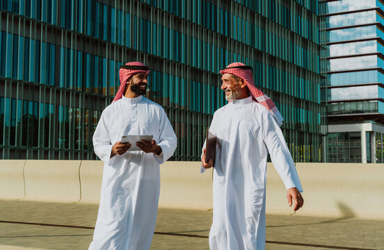 Arab businessmen discussing project outside modern building