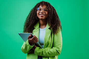 Fototapeta premium Smiling businesswoman using tablet on green background