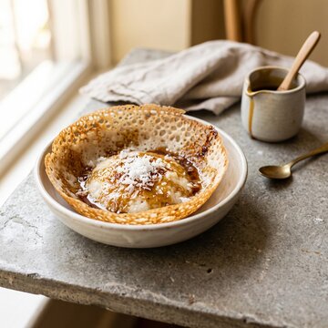Rustic Sri Lankan Pani Appa Sweet Hopper with Kithul Jaggery Syrup and Coconut &ndash; Lifestyle Food Photography with Copy Space