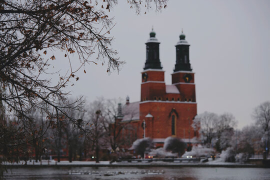 blurred Klosters kyrka in Eskilstuna, Sweden in the winter with tree branches.