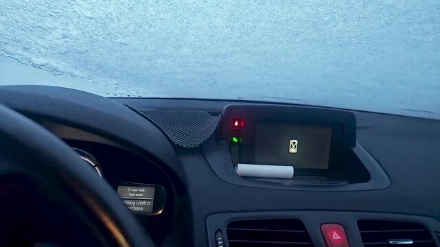 Inside Car View of Frozen Windshield Covered in Ice and Frost on a Cold Winter