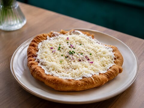 Comida t&iacute;pica servida en un plato con ingredientes y queso en una mesa de madera