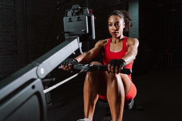 Obraz premium Fit young woman in red sport outfit making workout in the gym
