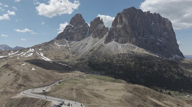 Man Standing on Mountain Ridge Overlooking Dramatic Alpine Peaks