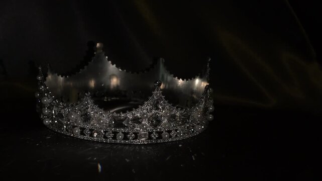Refined golden crown with gemstones on dark textured background, symbol of luxury and high status. Subtle light reflections create a sense of sophistication, exclusivity and elevated status. 