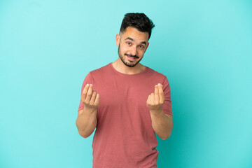 Fototapeta premium Young caucasian man isolated on blue background making money gesture but is ruined