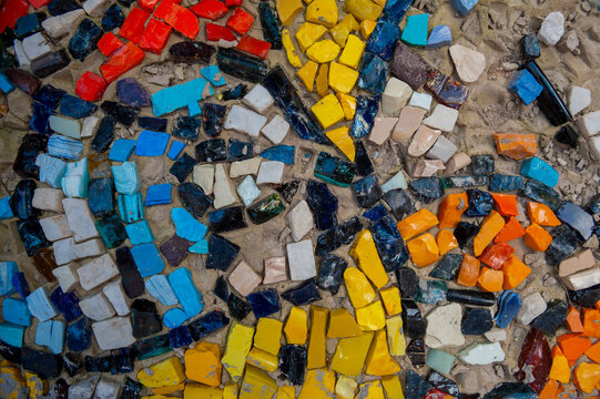 Colorful mosaic pattern with ceramic fragments on concrete surface