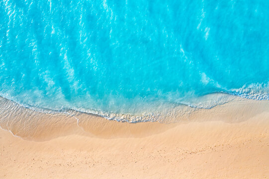 Turquoise ocean waves, white sand beach, aerial top view. Crystal clear tropical water, summer paradise background. Minimal seascape design, relaxing travel wallpaper, drone nature landscape scene