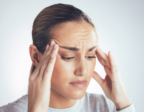 A woman in her 30s experiencing headache, emphasizing discomfort around temples and forehead.