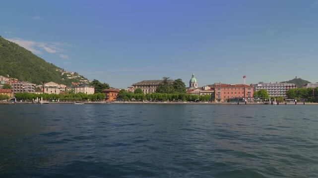 Panoramic timelapse video of the city of Como seen from the lake on a sunny day.