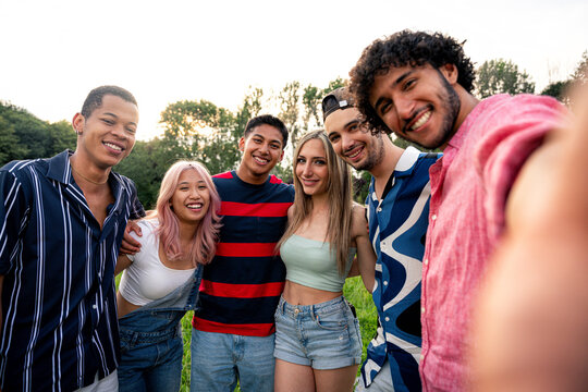 Group of multiethnic teenagers spending time outdoor on a picnic at the park
