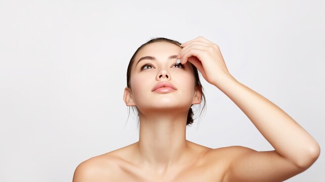 Young woman tilting her head back to apply eye drops for soothing relief and comfort in her eyes
