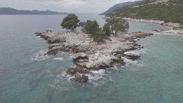 Small Rocky Island with Pine Trees in Turquoise Sea