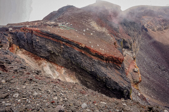 The rugged rim of Mount Fuji's summit crater reveals layered volcanic rock