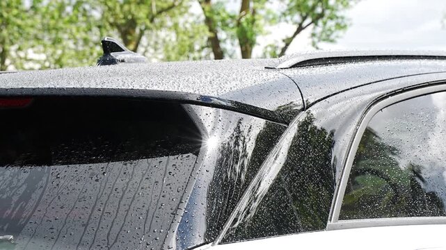 vehicle roof spoiler with rainwater droplets, capturing the intersection of automotive engineering and weather elements