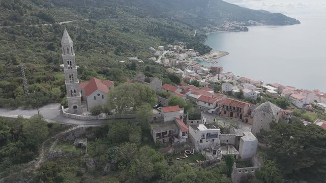 Aerial View of Coastal Village with Church Tower and Mountain Bay