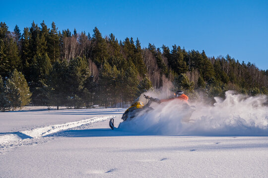 Athlete on a snowmobile moving in the winter forest in the mountains of the Southern Urals