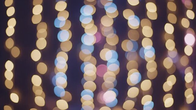 Abstract festive background with vertical rows of glowing golden and colorful bokeh lights.