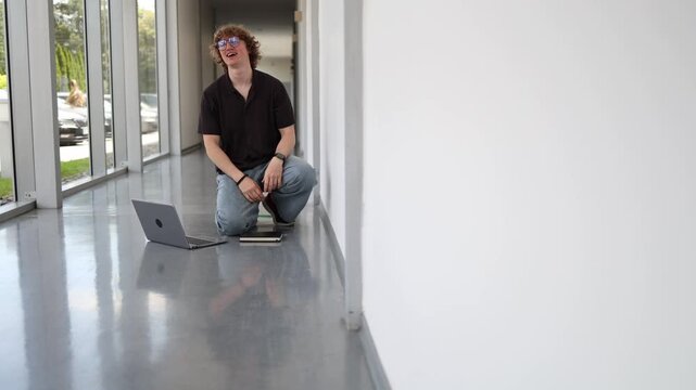 Stressed student lies on the school hallway floor trying to study after failing an exam showing disappointment anxiety determination and academic pressure